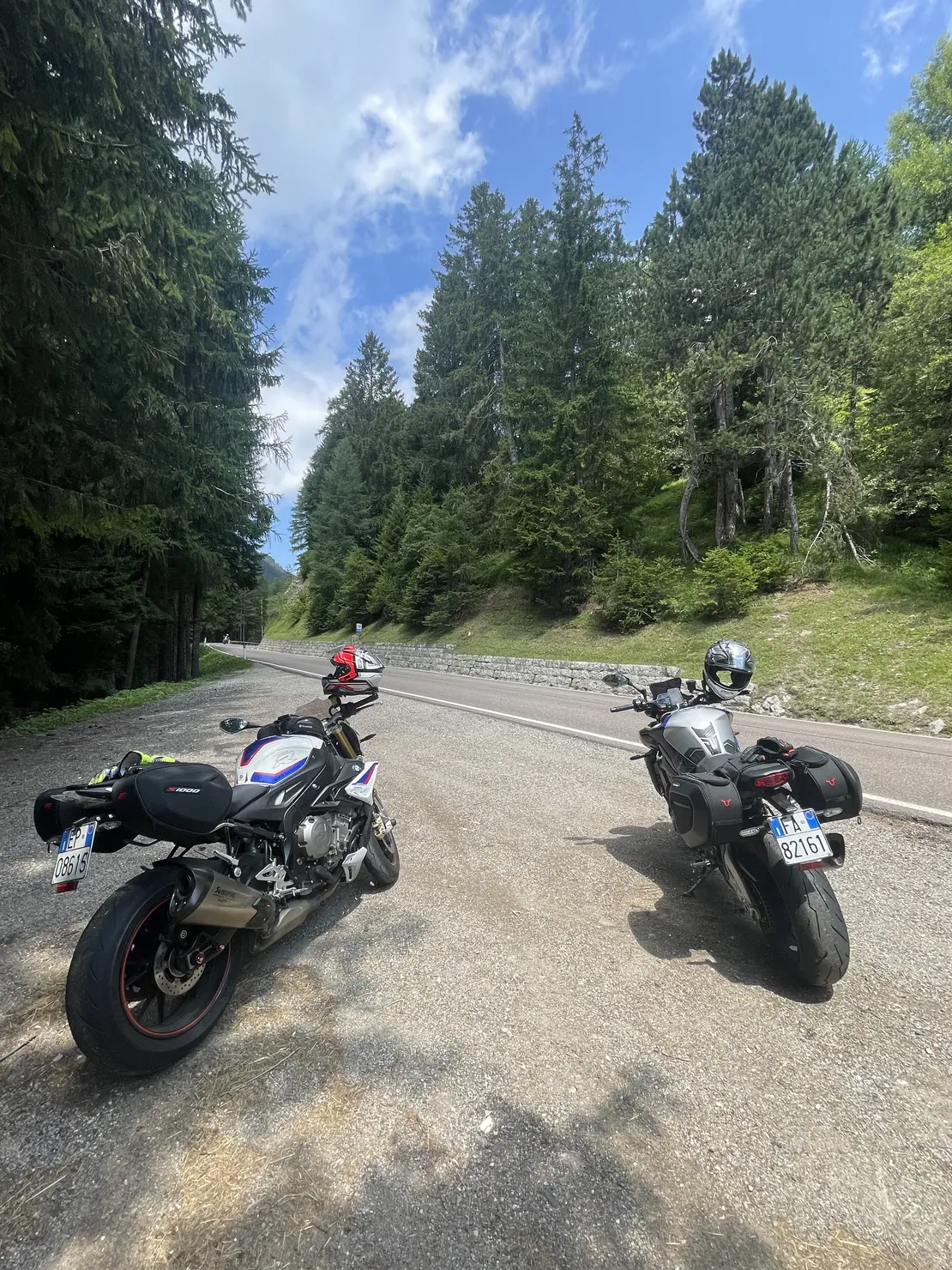 Motociclisti che percorrono una strada tra colline e vigneti