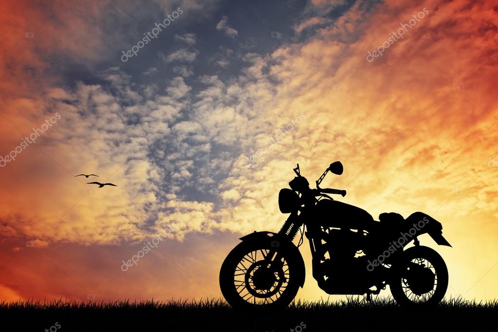 Moto in percorrenza lungo una strada che costeggia un lago calmo